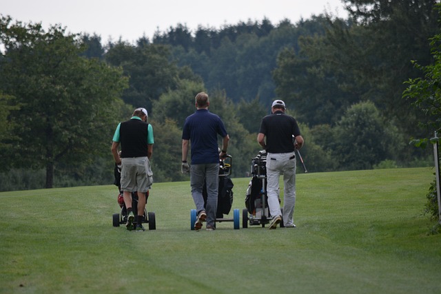 a group of golfers with electric golf trolleys on the fairway